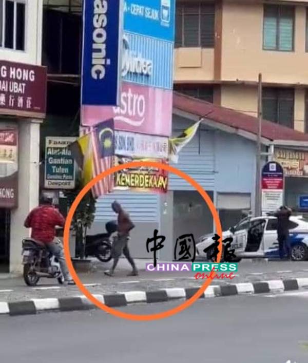 赤膊男醉汉（圆圈）正与一名骑乘摩哆的同族红衣男子对话，警车警员也在附近看守。