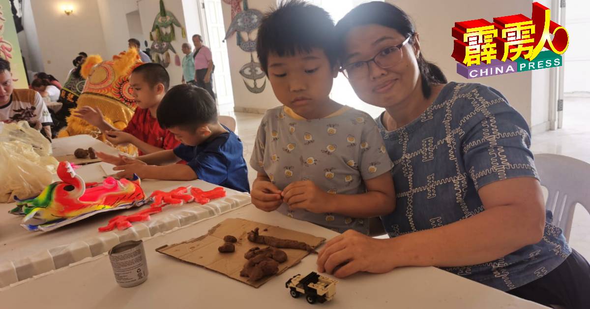 这名妈妈带了4名孩子来参观新村博览会，当中也让孩子尝试制龙香。