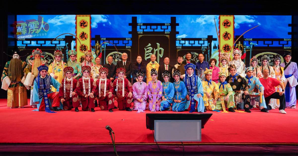 罗家英(中)与一众粤剧表演者,与嘉宾合照留念;后排左6起蔡贤德、曾钰成、黄金锭、常珊;后右9起丘宏义、郭俊亨、黄东春。