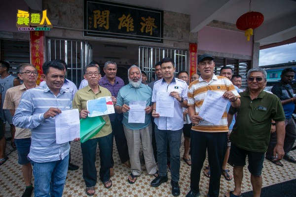 一行人展示无法更新的临时地契，右2为梁子祥，左2为郭生南。