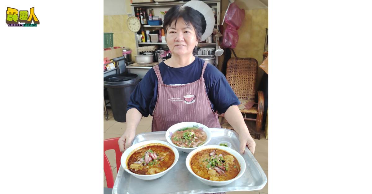 老板娘陈美喜捧着北京面（上）和红彤彤的吉隆坡面。
