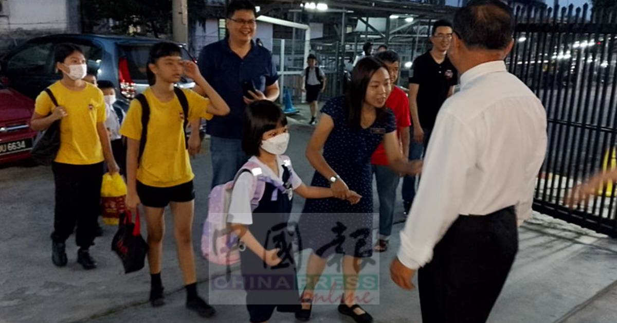一年级新生在老师陪同下，开心迈进培元小学大门。