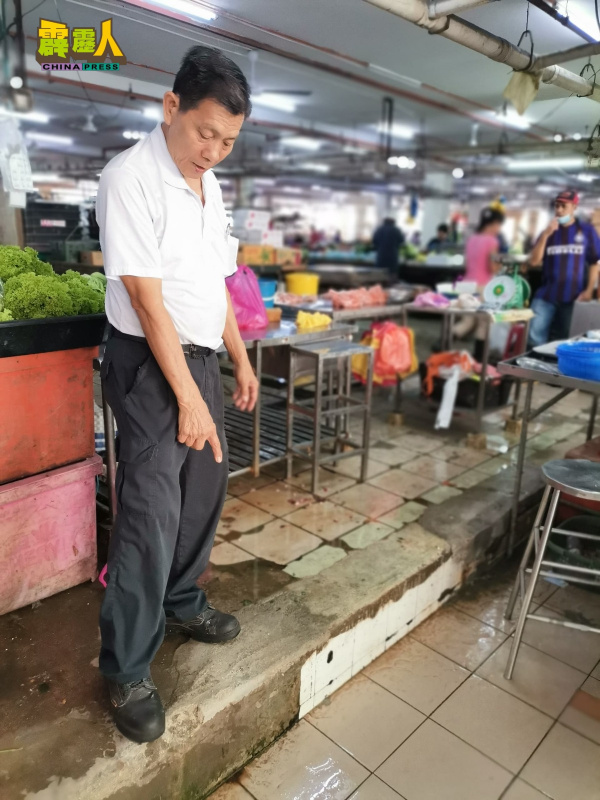 李炎龙指着甫获补洞的湿巴刹地面台阶,再次出现破损处。