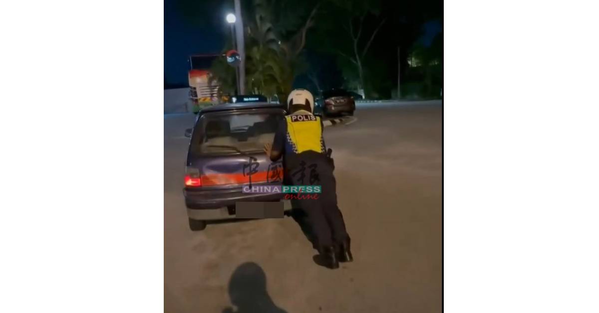 警察轮流推动抛锚轿车。