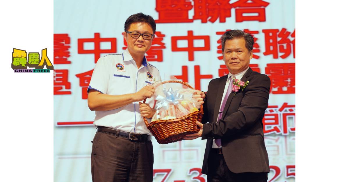 梁德成(右起)赠送水果礼篮给邢益腾。