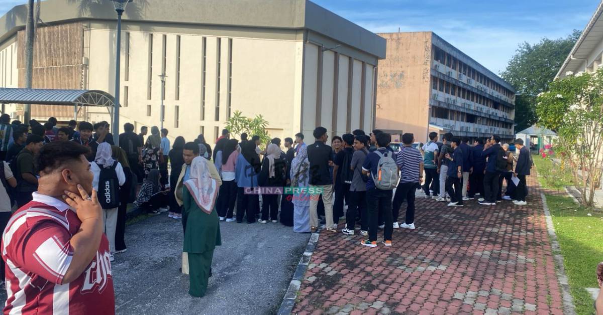 学生聚集在学院建筑外,等待进一步指示。