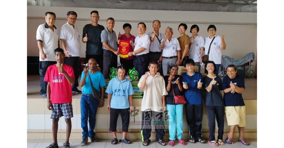 华都牙也残障儿童福利中心负责人赠表扬锦旗予和丰明德善社，由总务赖炳升（右6）代表接收。