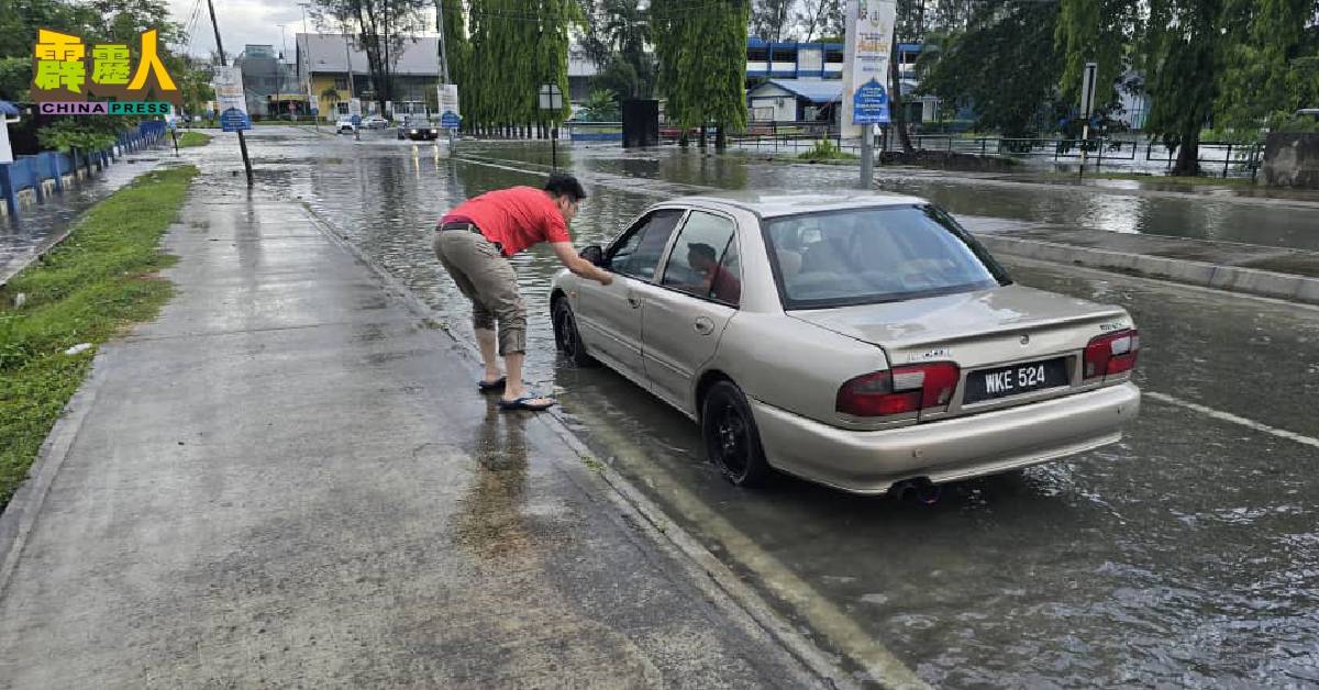 李存孝(左)正在视察突发水灾现场。