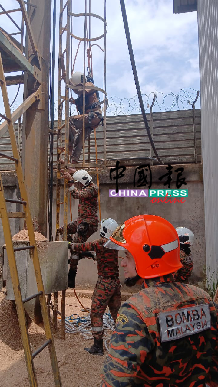 消拯员搭建滑轮系统将受困者(最高处)救出,一同爬梯下行到安全处。