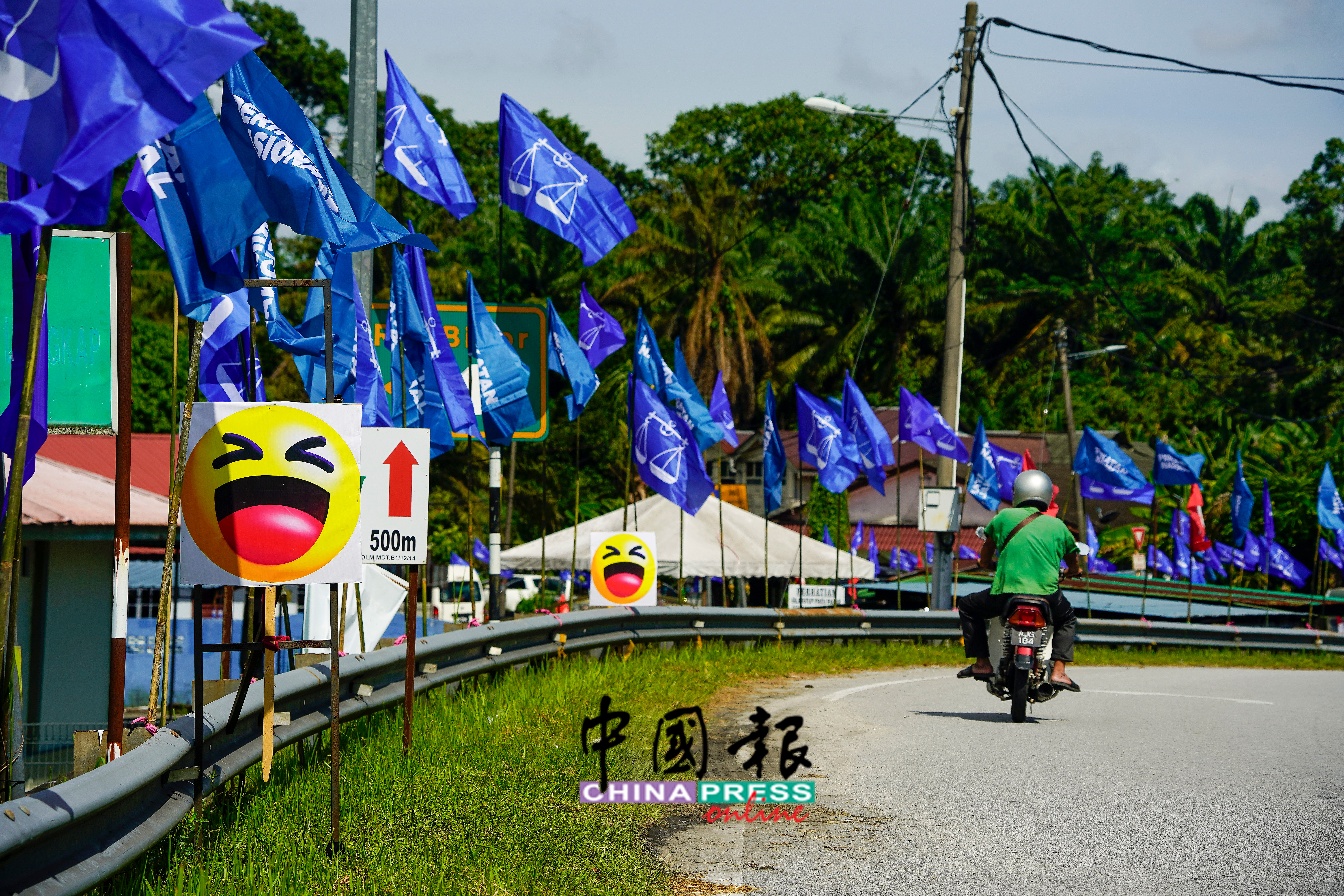 靠近美罗甘榜巴登（Kg Padang Bidor）的美罗与安顺路口，不仅出现国阵、国盟及义会主义党的旗帜，更是出现多个狂笑表情包（emoji）的牌子，引人瞩目。