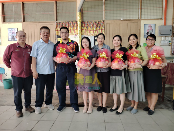 甘文丁培才华小被调动的5名华裔教师及1名巫裔教师,接领校方赠送的水果篮,左起为校长温进兴与董事长黄添福。