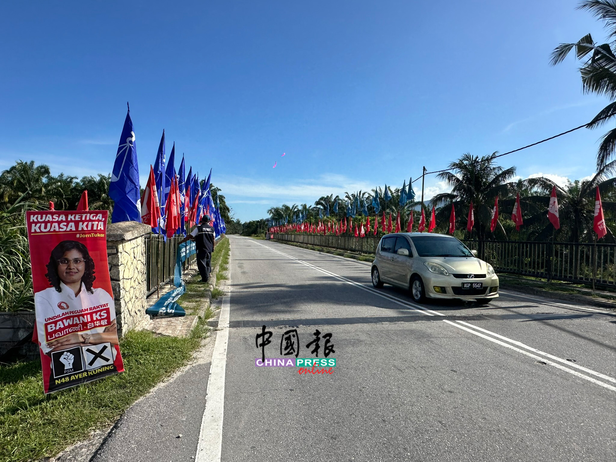 在通往亚亦君令新村的路上，沿途可见党旗林立。