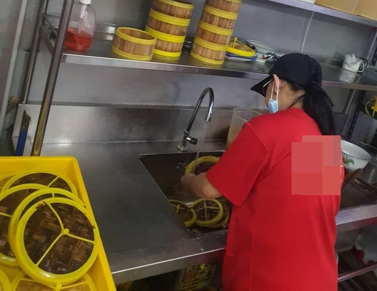 员工正在清洗竹蒸笼,确保没遗留任何食物残渣。