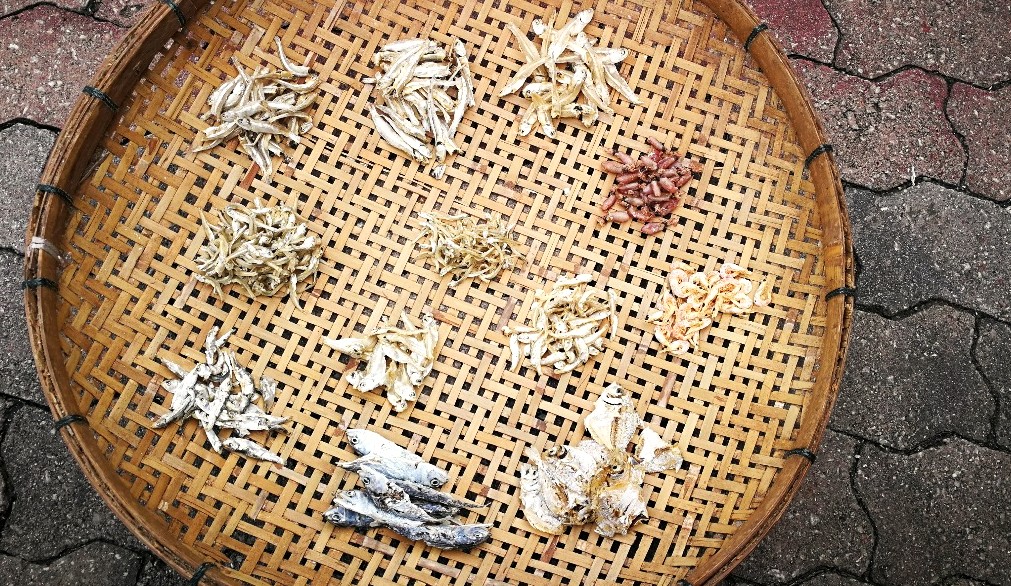 曝晒后的江鱼仔和其他海产,需人力筛选大小和分类。