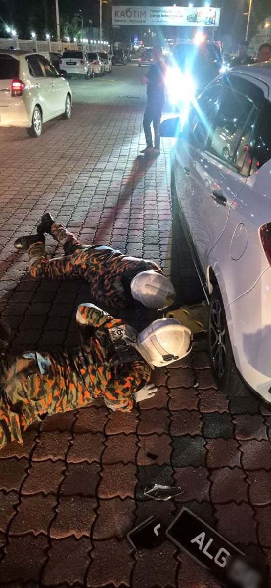 消拯员伏地施救，设法将受困男子从车底救出。