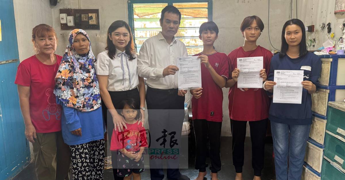 努莱娜(右起)、努莱妮及阿当,从张哲敏手中接过入学信而免去被停学的命运。左起为双溪古月新村村长李宝兰、穆雅裟罗及古海燕。