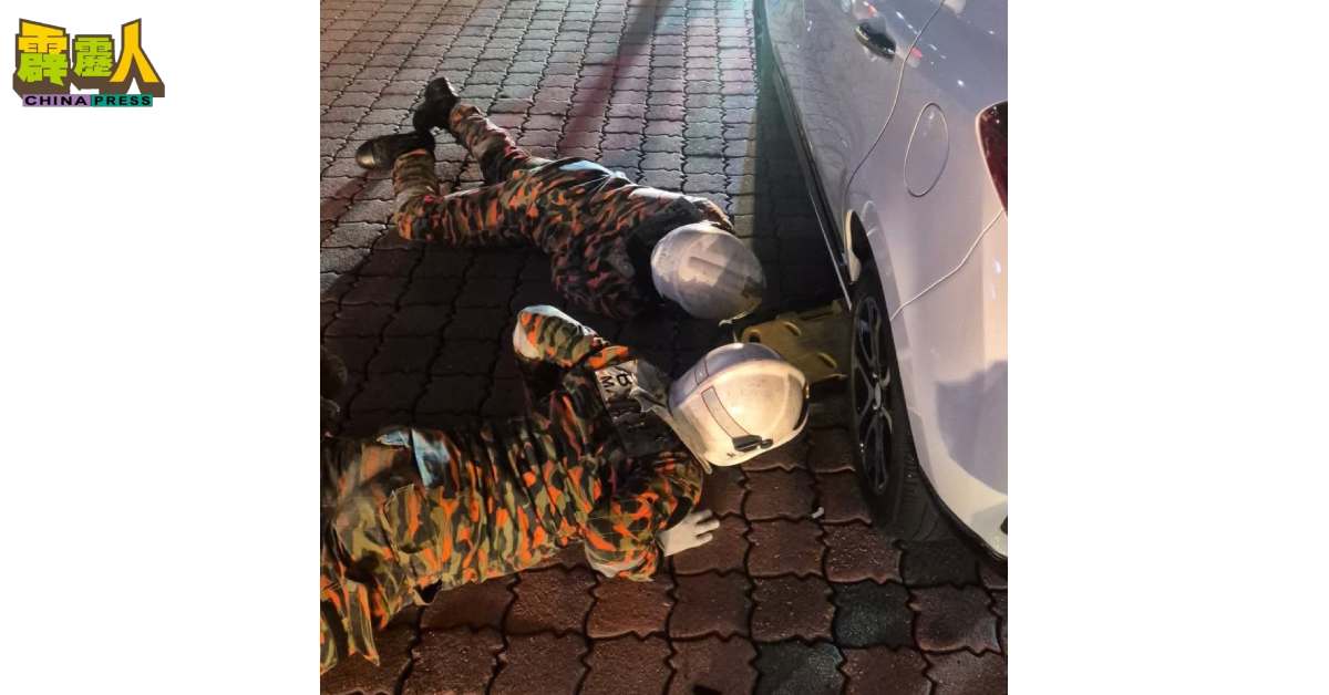 消拯员伏地施救,设法将受困男子从车底救出。