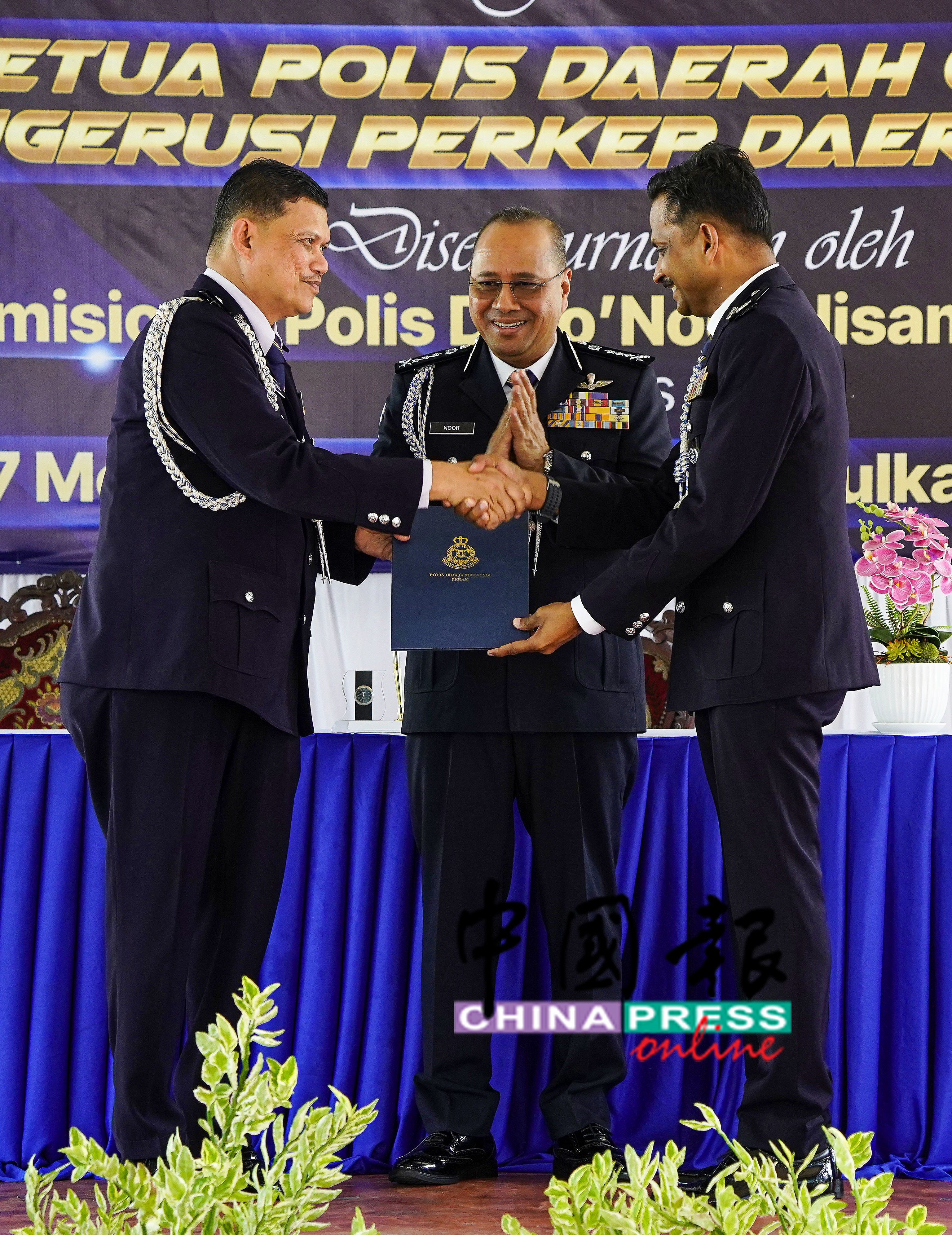 完成宜力警区主任移交职权仪式后,诺希山(中)见证调往武吉阿曼警察总部的祖基菲(左)与弗都斯(右)握手道别 。
