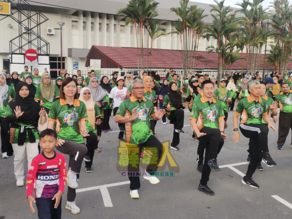 嘉宾和市议会领导人与参与徒步活动者一起做热身操,前左起为黄诗情、凯鲁阿米尔、王星元及莫哈末纳西尔。