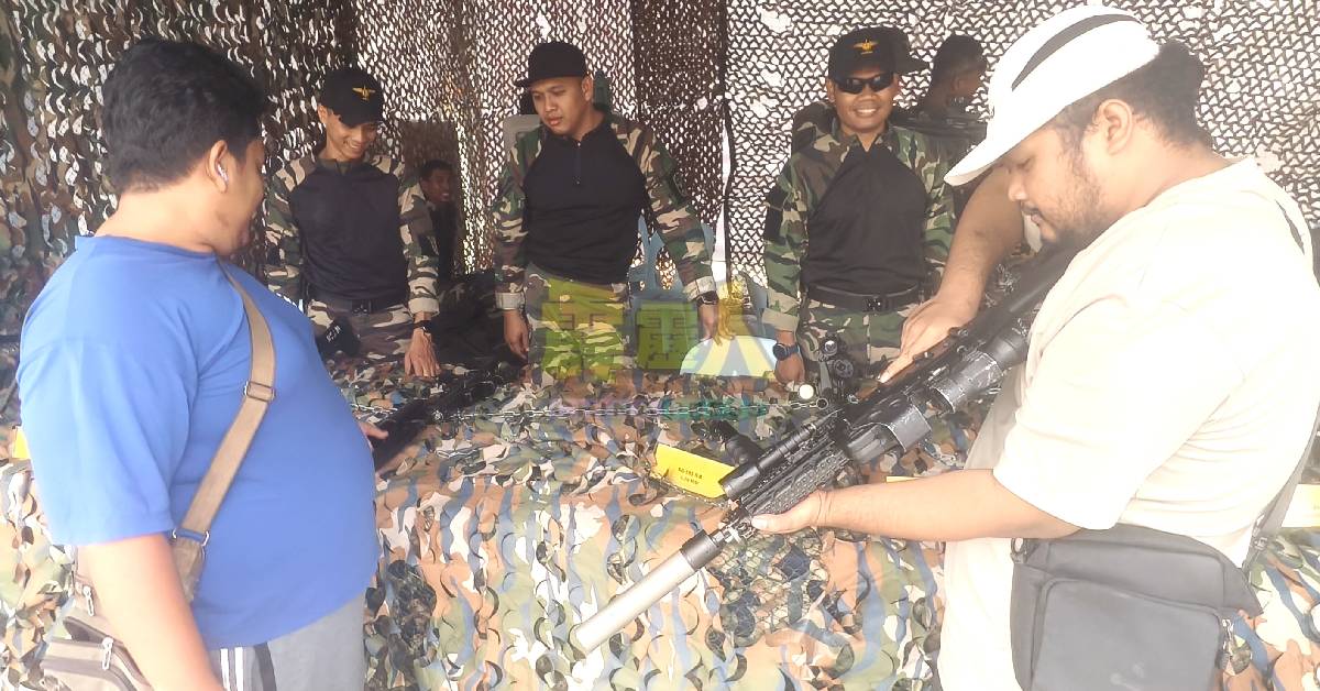 民众在活动场,有机会手握重型武器的体验。