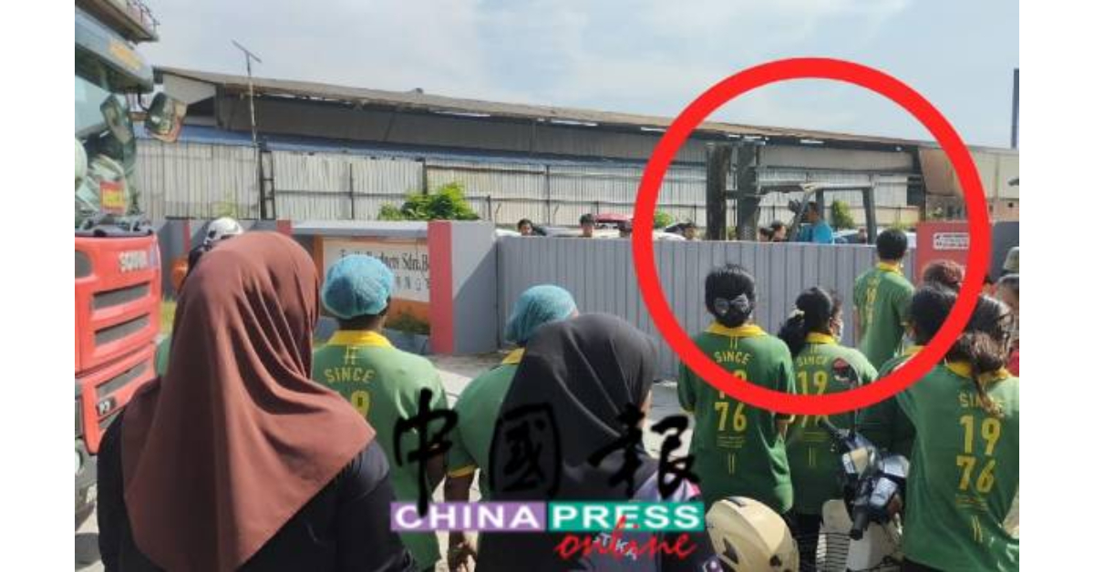 一名员工驾驶一架升降机(圆圈),始能将电动闸门推开,好让消防车进行救火。