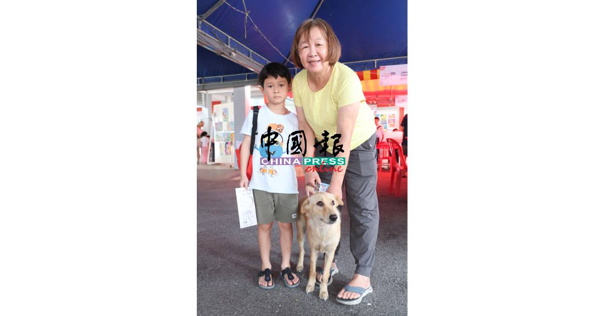 陈美莲(右)携带孙儿心爱的狗狗到来接种疫苗。