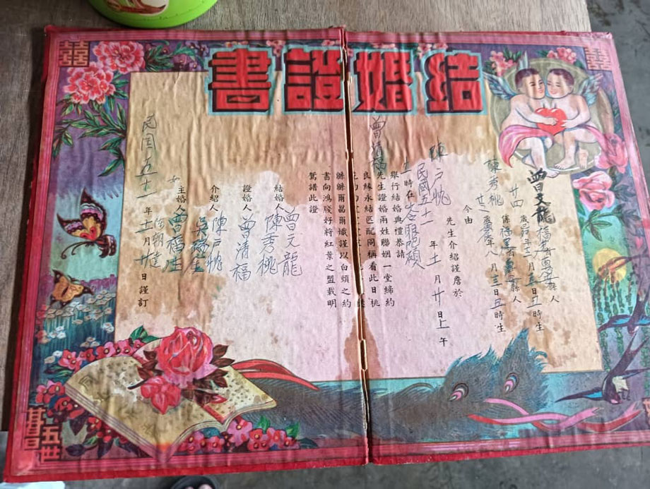 未被烧毁的厨房储物柜里竟然翻出父母当年的结婚证书，曾文龙、陈秀桃夫妇以及证婚人曾清福名字依然清楚可见。