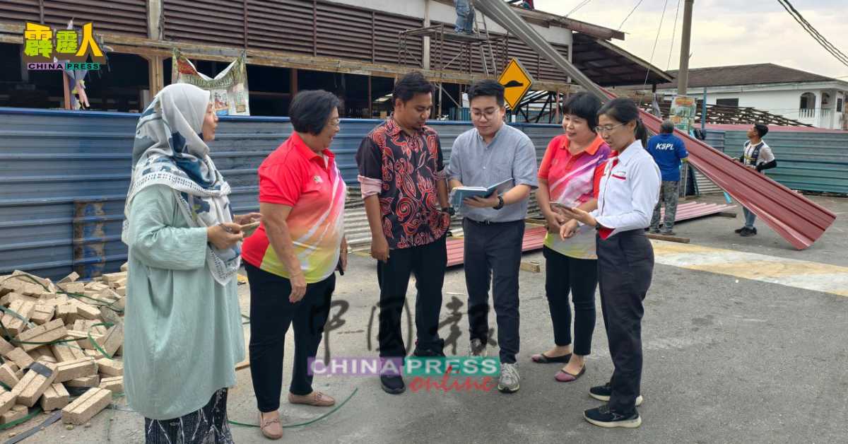 温凯程（右3）巡视提升工程地点时，与职员商讨工程详情。