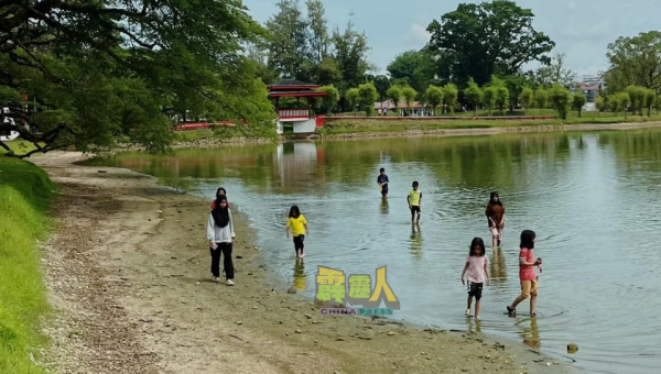 一些民众寻乐点子,踏足沙洲嬉乐,另一角度赏湖景。