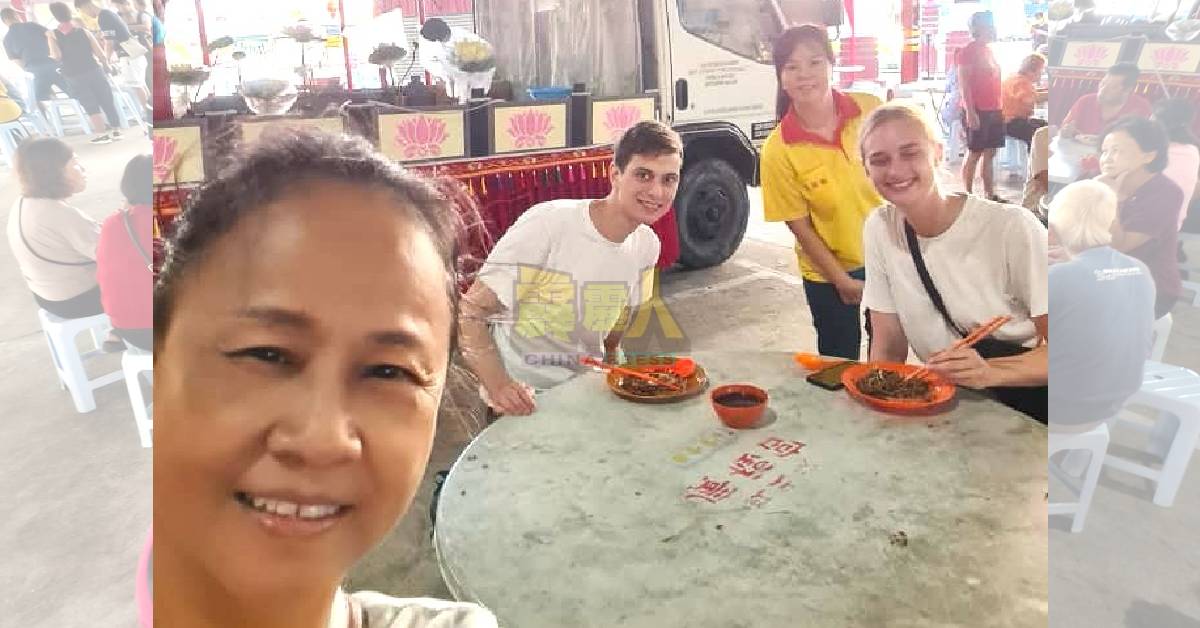 周玉珍（前左）邀请2名德国游客享用素食早餐。