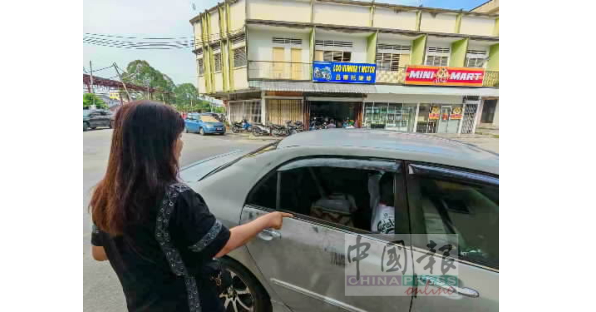 萧金婷指着后座右侧车镜,表示窃贼破镜后翻找后座包包,偷走财物。