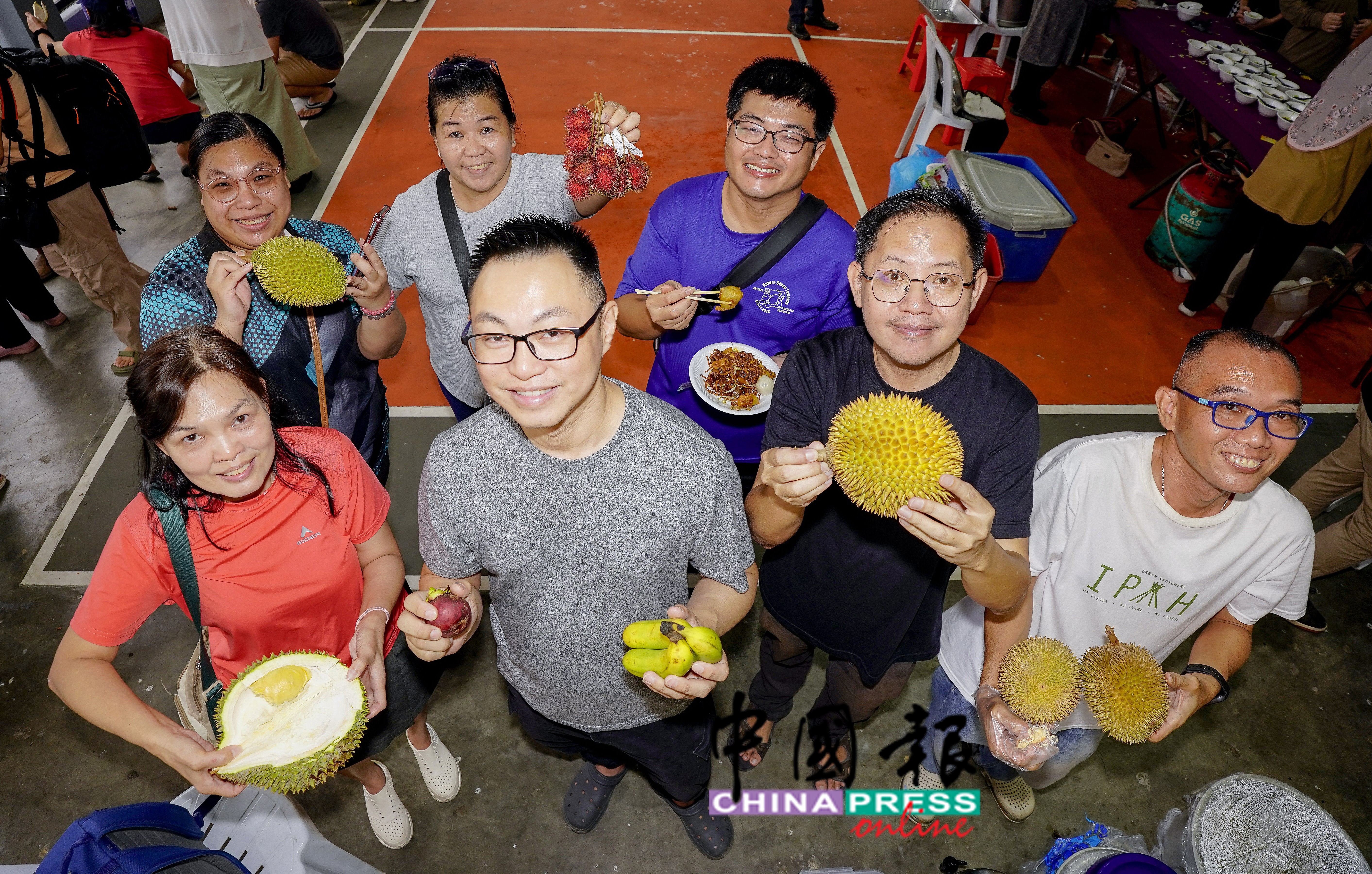 一群来自怡保的游客，到利民加地新村参加“2025年水果节盛会”，并与江沙的市民开心展示他们所取得的水果战绩。