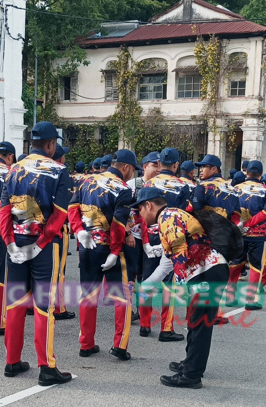 一些游行队伍的队员因长时期的操步,脚部肌肉抽搐,队友们替他喷射药物,以舒缓不适。