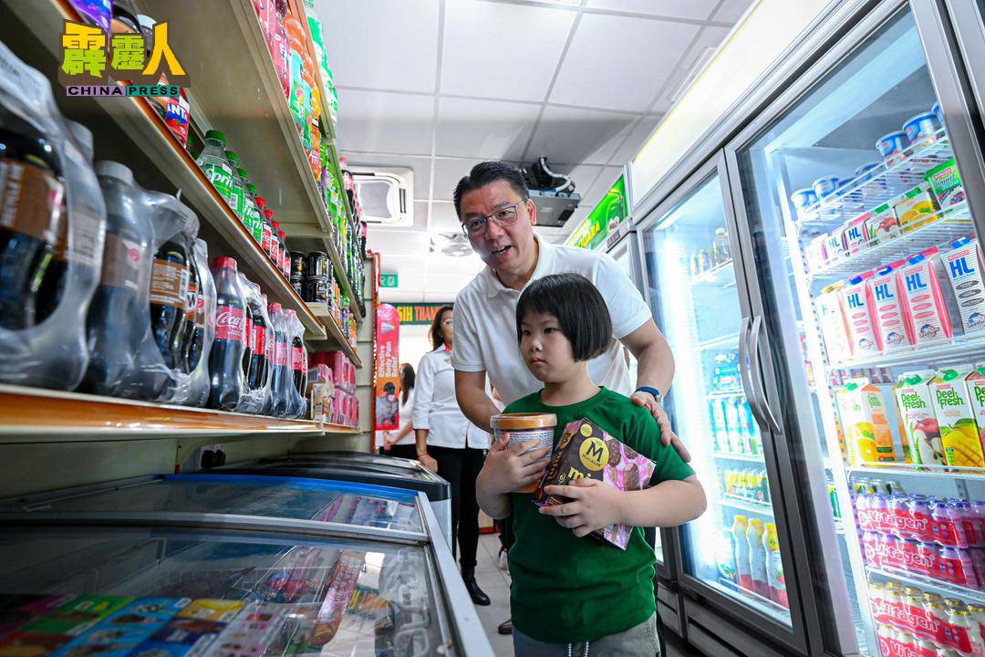 倪可敏(蹲者)在狮尾西湖园昌明公园标志石牌上签名。