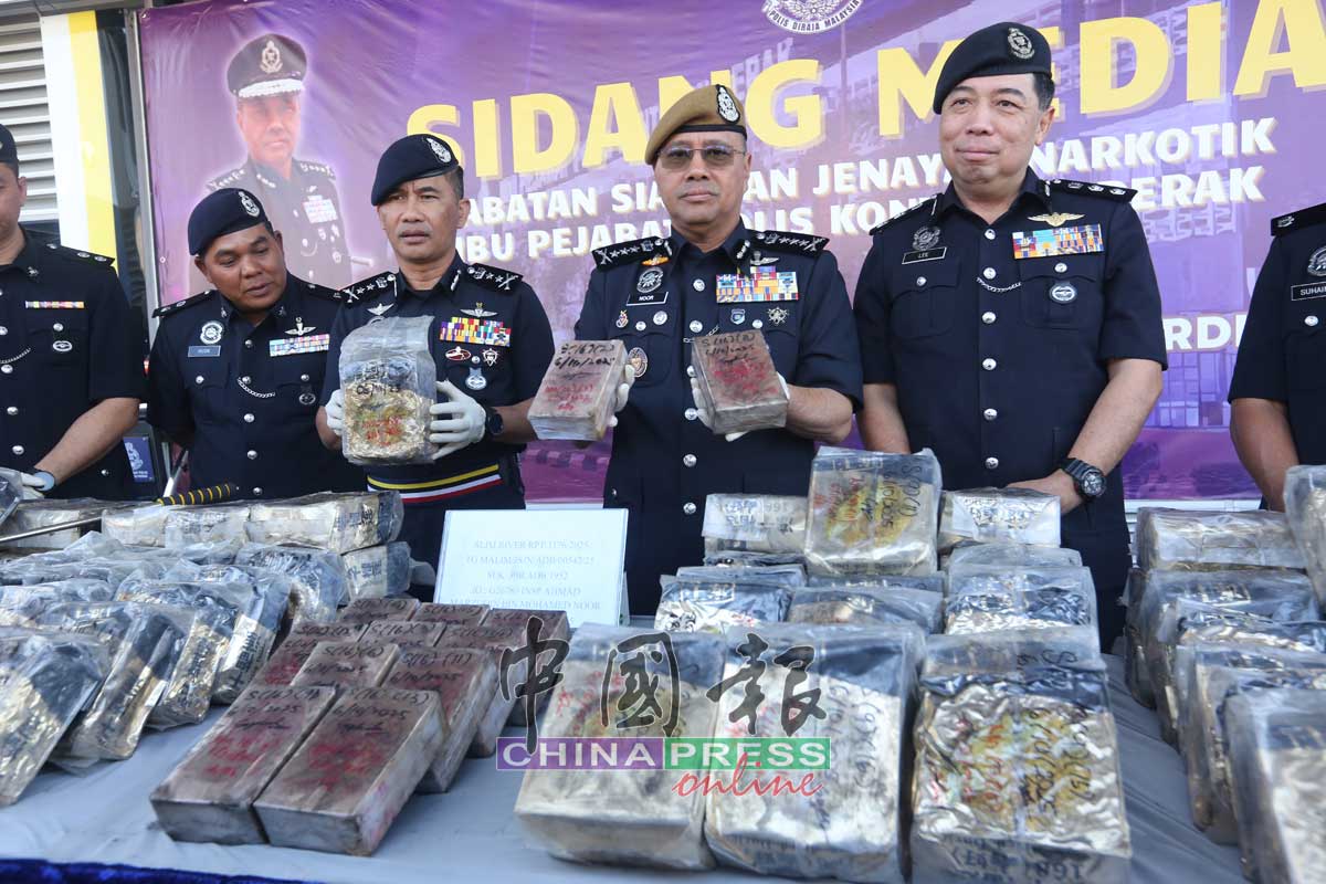 诺希山（右）展示警方所起获的毒品。