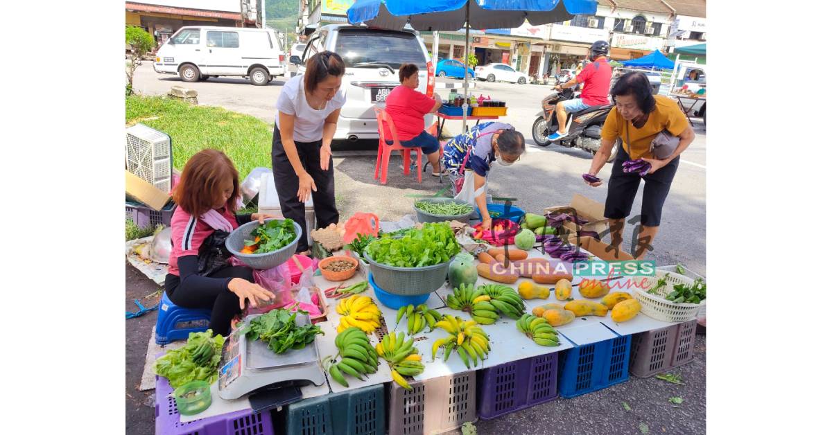 小贩在街头摆摊及售卖食料,路过的市民都会顺道选购一些蔬果。