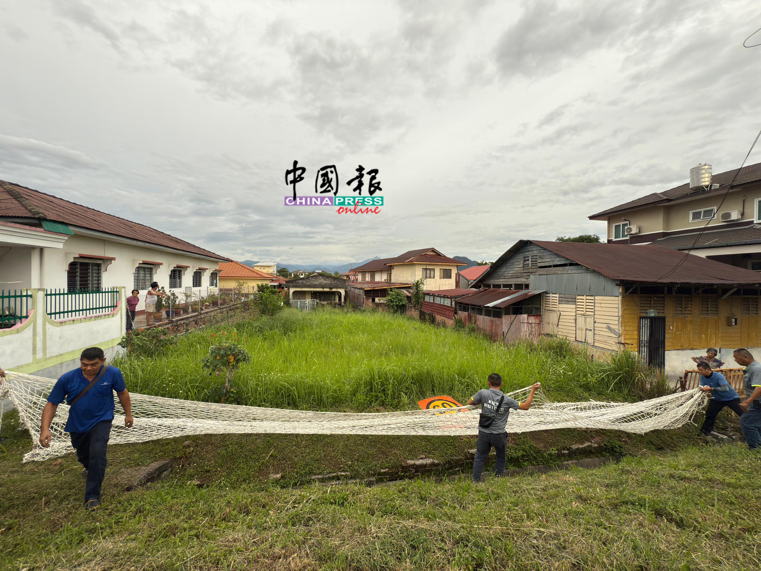 考虑到山猪具攻击性,队员分工合作,使用特製防护网将其安全捕捉。(怡保新街场义务消防队提供)