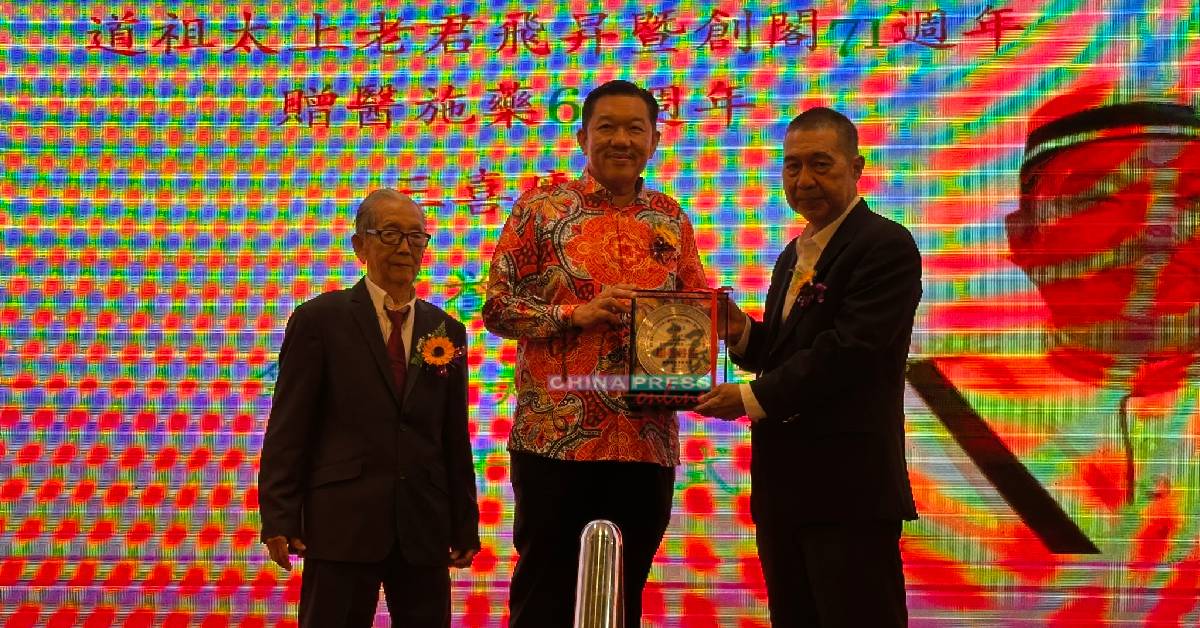 陈建铭（右起）赠送纪念品给许美远，由谭简衢（左）陪同。