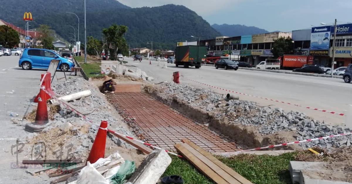 工人在已竣工的巴都新纳路排水系统做善后工作。