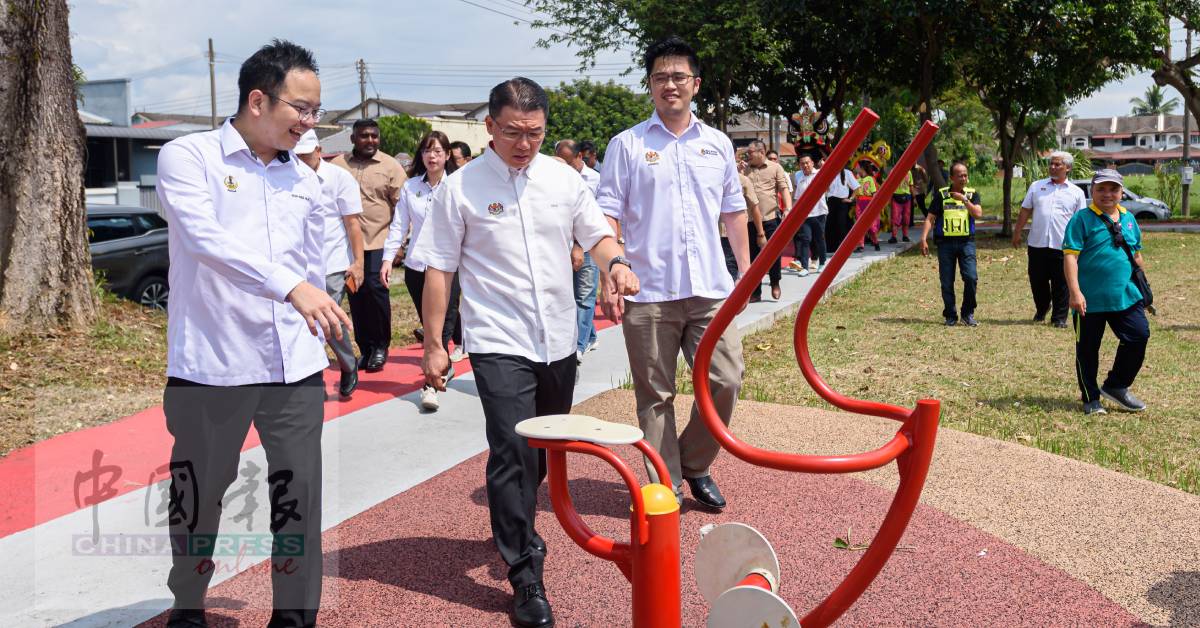 ■倪可敏(中)在吴锡华等人陪同下,在昌明公园内做引体上升运动。