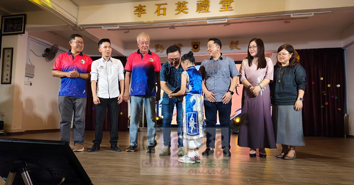 1名女学生移交平板电脑予郑立慷启动开幕仪式。由陈奕儫、蔡旺森、袁运昌、郑闵珲、倪凤凤、曾银莹陪同。
