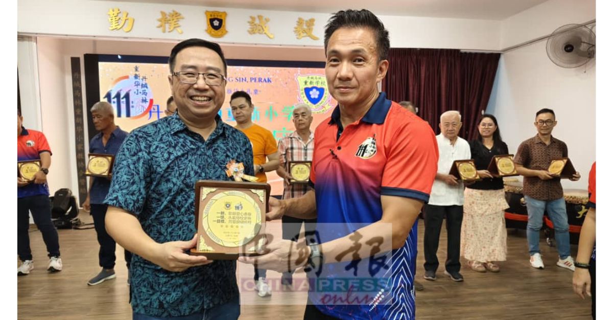 郑立慷（左）颁发纪念盾牌予捐献11万1800令吉基金的林志华。